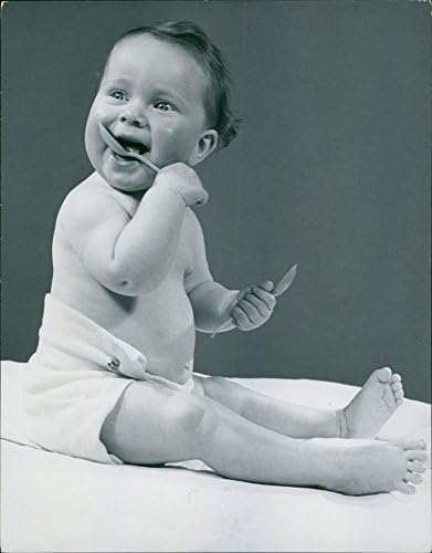 Foto vintage de bebê brincando com colher.