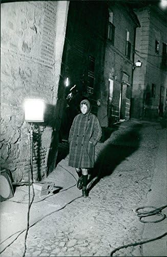 Foto vintage de Sarah Miles andando no beco.